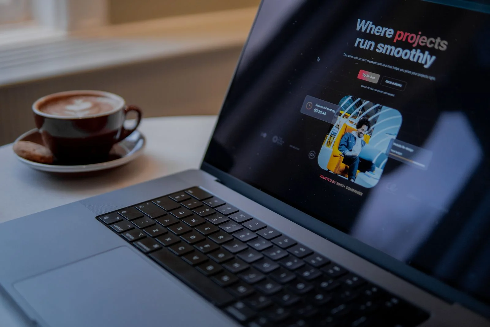 Laptop z otwartą stroną internetową obok filiżanki kawy