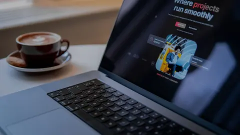 Laptop z otwartą stroną internetową obok filiżanki kawy